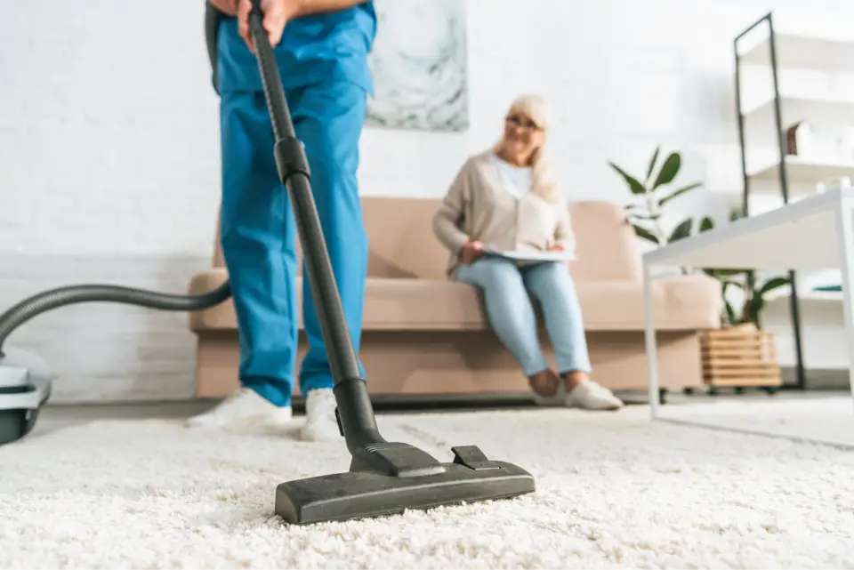 Person vacuuming a clean living room.