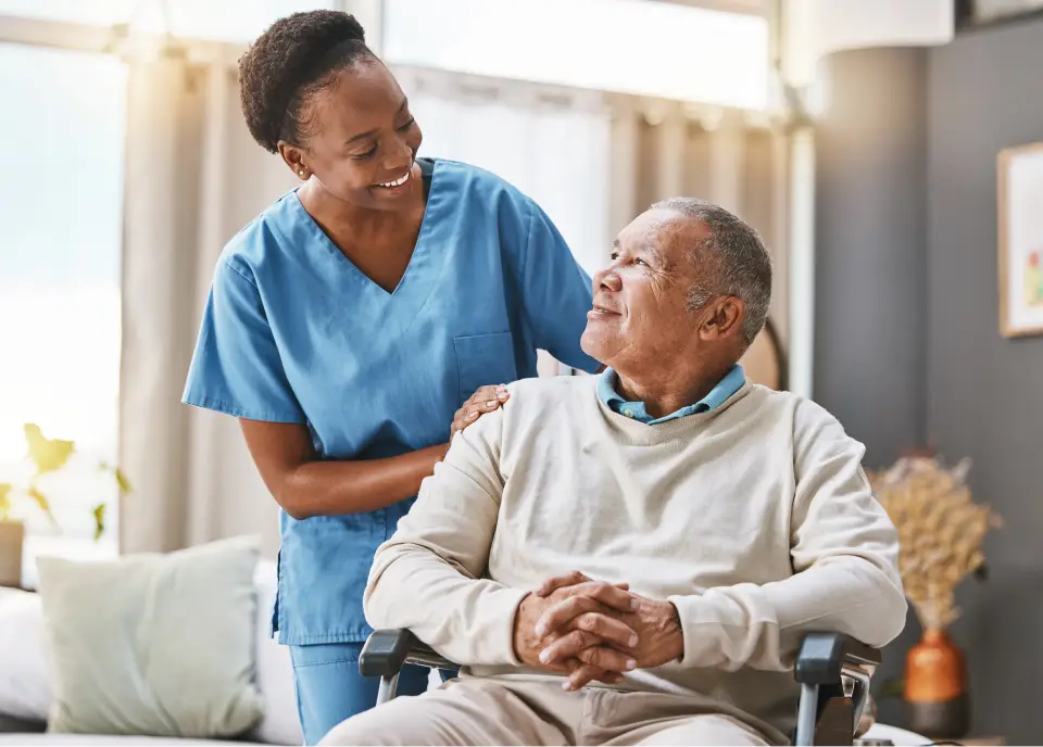 Nurse assisting elderly patient in wheelchair.